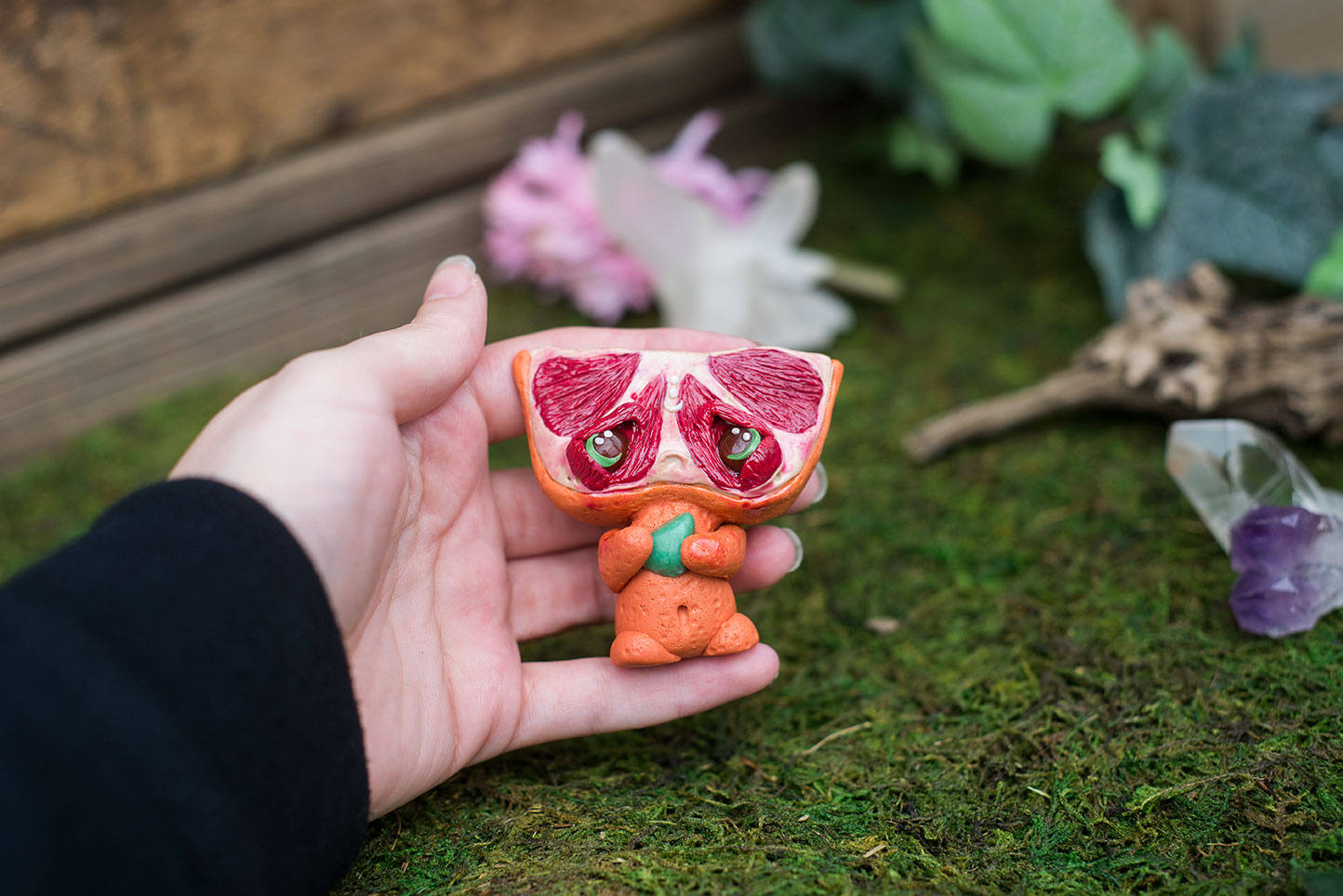Size Comparison in Hand of Blood Orange Mish - handmade polymer clay blood orange creature holding tumbled adventurine