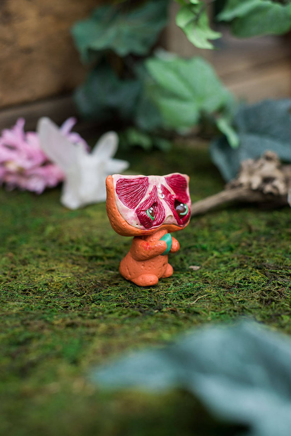 Right-Side View of Blood Orange Mish - handmade polymer clay blood orange creature holding tumbled adventurine