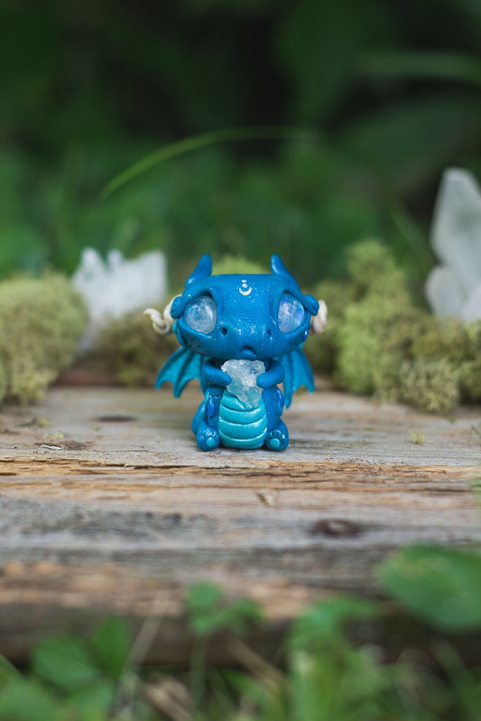 Front View of Blue Dragon Mish - handmade polymer clay dragon creature with tail and wings, holding aquamarine crystal