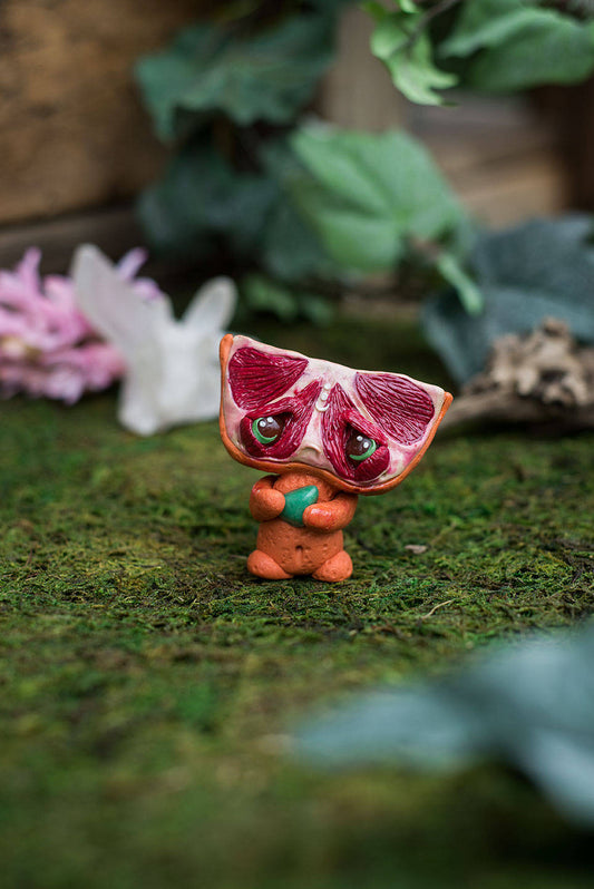 Front View of Blood Orange Mish - handmade polymer clay blood orange creature holding tumbled adventurine
