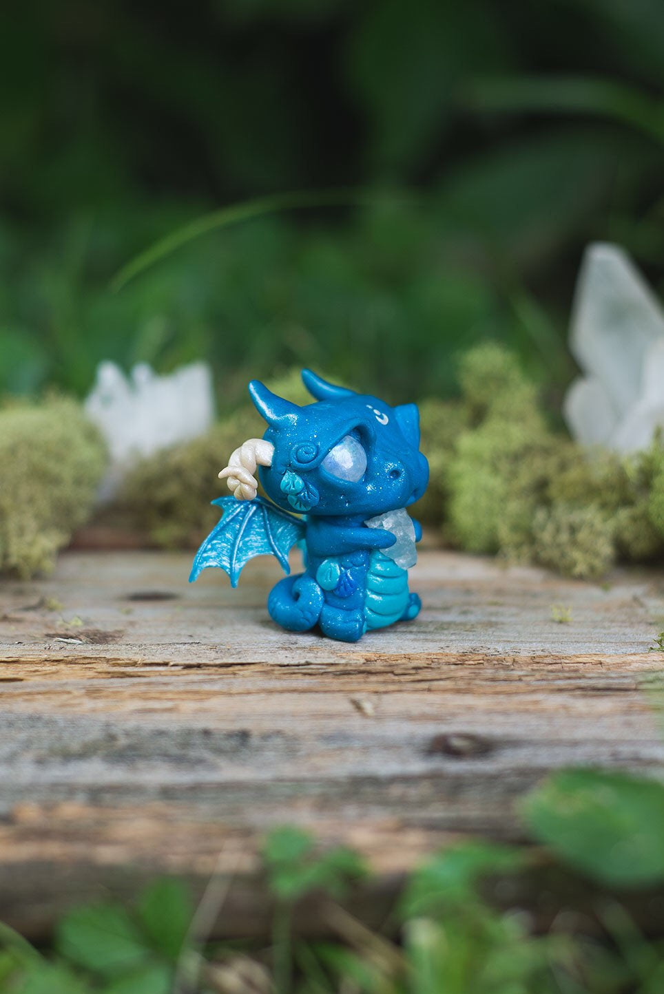 Right-Side View of Blue Dragon Mish - handmade polymer clay dragon creature with tail and wings, holding aquamarine crystal