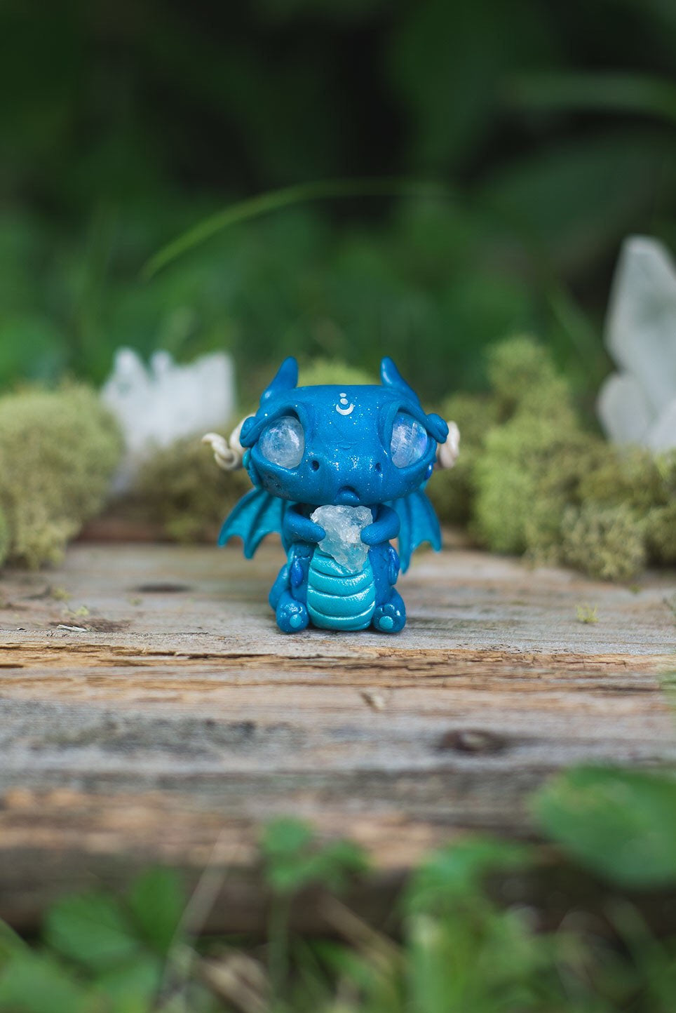 Front View of Blue Dragon Mish - handmade polymer clay dragon creature with tail and wings, holding aquamarine crystal